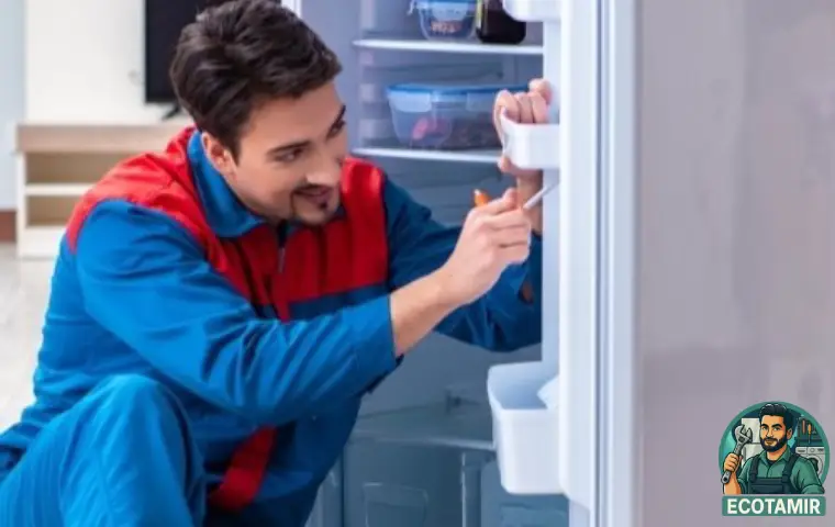 تعمیرکار مرد در حال بررسی و تعمیر یخچال 